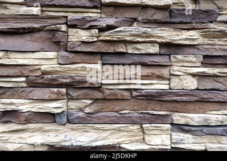 Wall stonework finishing from colorful natural stone trim as background front view close up Stock Photo