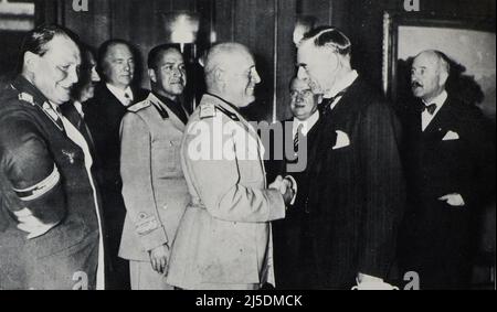 Eng translation : ' At the end of the conference: Mr. Mussolini shakes hands with Mr. Chamberlain. Left: Marshal Goering and the Führer, then Count Ciano; in the middle: Mr. Daladier; right: the French ambassador. ' - Original in french : ' A l'issue de la conférence : M. Mussolini serre la main de M. Chamberlain. A gauche : le maréchal Goering et le Führer, puis le comte Ciano ; au centre : M. Daladier ; à droite : l’ambassadeur de France. ' - Extract from 'L'Illustration Journal Universel' - French illustrated magazine - 1938 Stock Photo