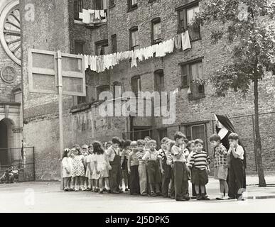 Nun with group of young schoolchildren in Playground, New York City, New York, USA, Angelo Rizzuto, Anthony Angel Collection, September 1949 Stock Photo