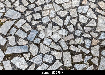 Granite stone pavement with random shaped fragments, top view, cobblestones background photo texture Stock Photo