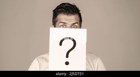 Man a question. Doubtful man holding Question Mark. Problems and solutions. Getting answers. Portrait of man, peeking behind of interrogation symbol Stock Photo