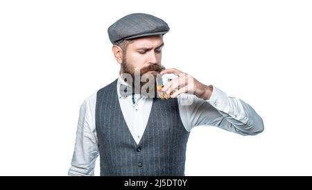 Sommelier tastes expensive drink. Bearded man wearing suit and drinking whiskey, brandy, cognac. Bearded in is holding a glass of whiskey Stock Photo