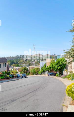 Asphalt road with parked vehicles on a sloped residential area in San Francisco, California Stock Photo