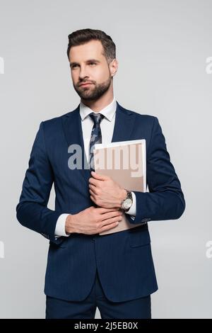 bearded businessman with folder looking away isolated on grey Stock Photo