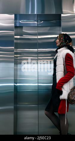 young woman standing waiting for an elevator Stock Photo