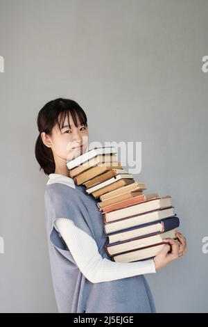 Girl carrying stack of books against white background Stock Photo - Alamy