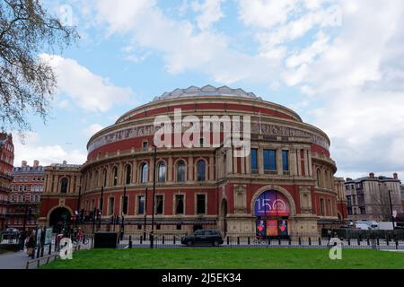 London, Greater London, England, April 13 2022: Taxi and Motorbike pass the Royal Albert Hall, a famous concert hall in South Kensington. Stock Photo