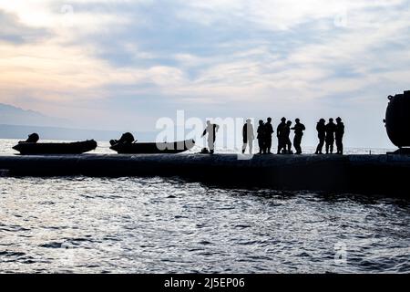 Souda Bay, Greece. 05 April, 2022. U.S. Marines from Task Force 61/2 perform launch and recovery training on their combat rubber raiding craft with the Navy nuclear-power Ohio-class ballistic-missile submarine USS Georgia, March 27, 2022 in Souda Bay, Greece.  Credit: Sgt. Dylan Chagnon/U.S. Navy/Alamy Live News Stock Photo