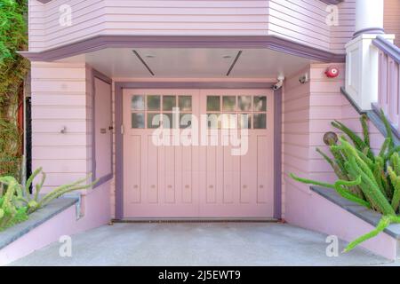 Garage exterior with side hinged double door and pink wood lap siding at San Francisco, California Stock Photo