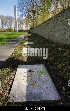 Hamburg, Germany. 22nd Apr, 2022. 22 April 2022, Hamburg: Flowers lie on a memorial stone with the Cyrillic characters CCCP at the Neuengamme Concentration Camp Memorial in Hamburg, which translate to 'Union of Soviet Socialist Republics.' The memorial was inaugurated in 1965 and is a protected monument. Twenty-two stones mark the nations of origin of the prisoners as they existed on the political map before the outbreak of World War II. Because of the Ukraine war, the Neuengamme Concentration Camp Memorial in Hamburg did not invite official representatives from Russia and Belarus to the 77th  Stock Photo