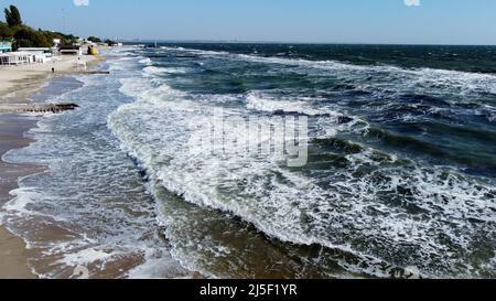 People walking and relaxing on beach on sunny day. Aerial Drone View Flight Over Stock Photo