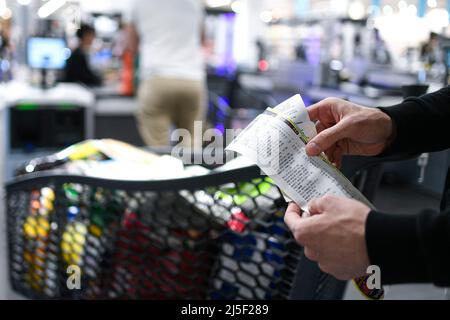 Paris. France. 22nd Apr, 2022. A customer checks his paper receipt as exiting a supermarket on April 22, 2022 in Paris. France is to end paper receipts for all transactions as standard by January 1, 2023 - including for shopping with cash, card, or vouchers; parking, and withdrawing money at ATMs. The move, dubbed the “anti-waste law”, is intended to save paper and resources. Customers will still be able to request a receipt if they wish. The new rule will apply to nearly all instances in which a paper receipt may currently be issued, including all commercial centres, shops, car parks, and ATM