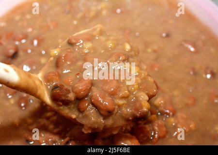 A ladle full of Egyptian fava beans which is the main dish and sandwich in the breakfast in Egypt, cooked with crushed bean, yellow lentils and wheat, Stock Photo