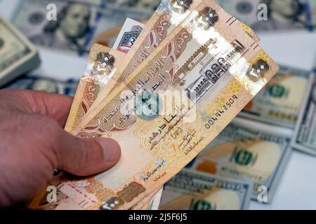 man hand holding a stack of United Arab Emirates 200 two hundred dirhams money, spending, giving and using money concept, paying and buying using bank Stock Photo