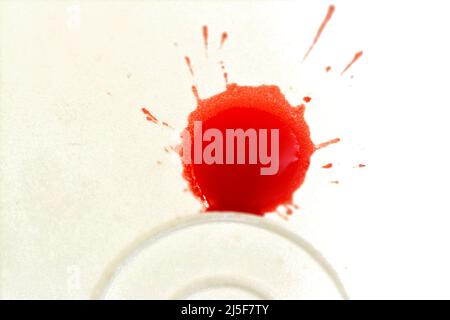 Selective focus of a blurred blood splatter splash on a white ground, red blood drop, bleeding, suicide, homicide, crime scene, medical and healthcare Stock Photo
