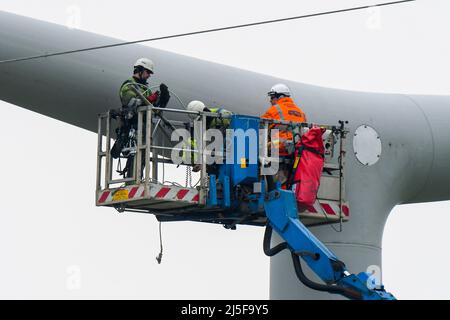 Bridgwater, Somerset, UK.  23rd April 2022.  Workmen on an aerial platform working on one of the new National Grid T-Pylons at Bridgwater in Somerset which have been built across the Somerset levels as part of the Hinkley Point C.  Picture Credit: Graham Hunt/Alamy Live News Stock Photo