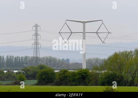 Bridgwater, Somerset, UK.  23rd April 2022.  General view of one of the new National Grid T-Pylons at Bridgwater in Somerset which have been built across the Somerset levels as part of the Hinkley Point C nuclear power station project.  Near it is one of the traditional lattice pylons.  Picture Credit: Graham Hunt/Alamy Live News Stock Photo