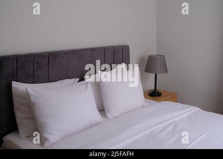 clean modern bedroom with white bedding. minimal interior. good sleep and relaxation Stock Photo