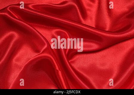Texture of crumpled red satin fabric, beautiful pattern. Stock Photo
