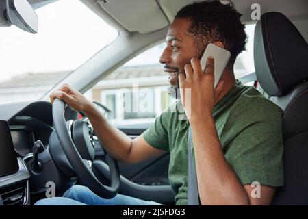 Man Talking On Mobile Phone Whilst Driving Car Stock Photo