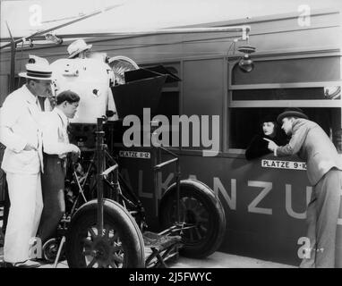 Director SAM WOOD Cinematographer JAMES WONG HOWE MYRNA LOY and GEORGE BRENT on set candid during filming of STAMBOUL QUEST 1934 director SAM WOOD story Leo Birinsky screenplay Herman J. Mankiewicz wardrobe Dolly Tree Metro Goldwyn Mayer Stock Photo