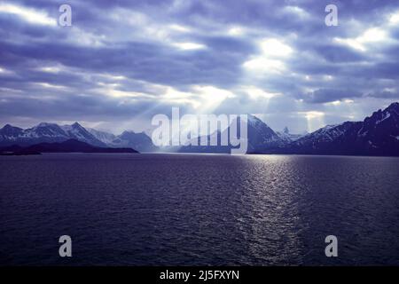 Dark moody sky with light rays over the coast of Norway Stock Photo
