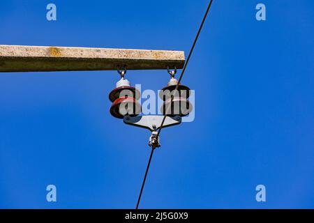 Close up of a power pole with insulators and a power line in Germany Stock Photo