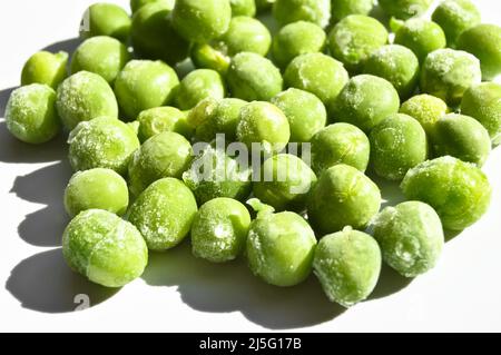 Fresh green frozen peas and grains, nutritious and healthy green vegetables, isolated on white background Stock Photo
