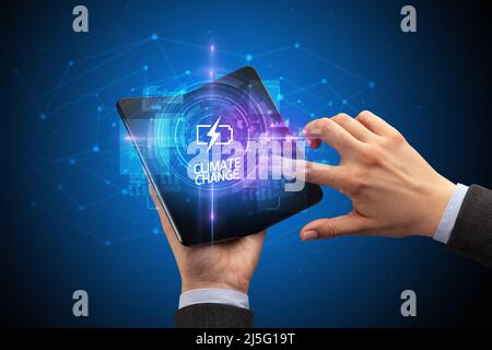 Businessman holding a foldable smartphone, technology concept Stock Photo