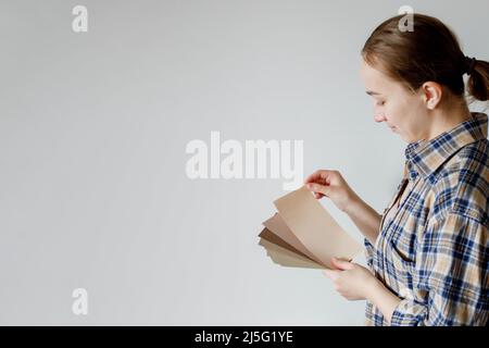 Young woman holds in her hand color paint samples for the wall Stock Photo