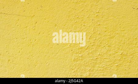 Yellow painted cement surface. Texture of old wall covered with yellow stucco. Grunge color painted background Stock Photo