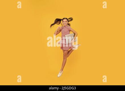 happy child girl hurry up running hold notebook to find sale and discount, energy Stock Photo