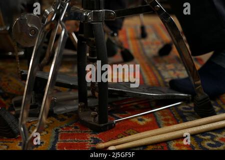 drumsticks are lying on the floor near the drum kit. Pedal high-hat Stock Photo