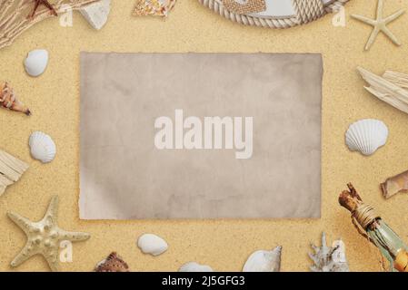 Clean old paper on beach surrounded with seashells and shipwrecks parts. Copy space. Top view, flat lay composition Stock Photo