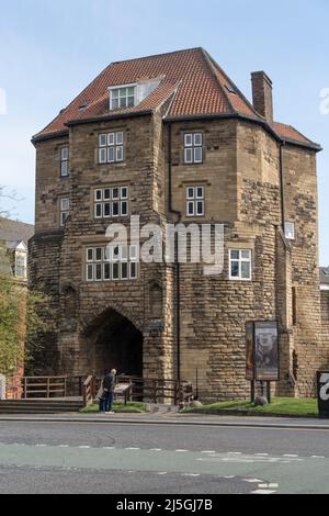 Two people read an information board outside The Black Gate of Newcastle Castle, Newcastle upon Tyne, UK Stock Photo