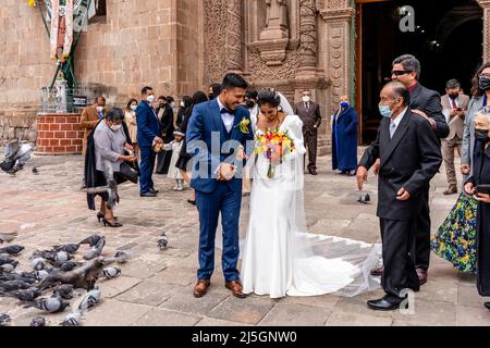 A Young Peruvian Couple Leave The Cathedral After Getting Married, The Plaza de Armas, Puno, Peru. Stock Photo