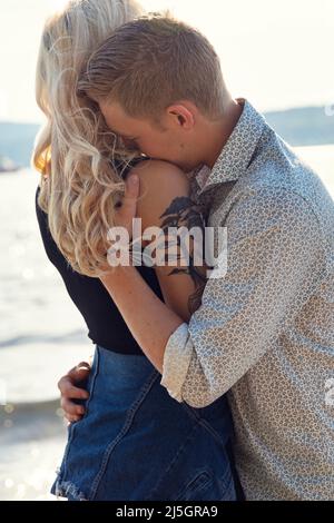 Young Man Embracing Emotional Girlfriend At Beach Stock Photo