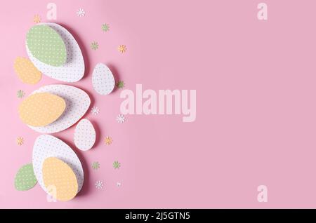 Easter background. Easter eggs cut out of paper for scrapbooking - yellow, white and green with polka dots on a pink background with copy space Stock Photo
