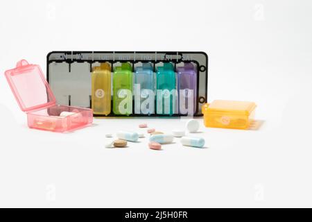 pill dispenser opened and loose pills isolated on a white background Stock Photo