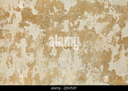 Old yellowed, dilapidated and uneven wall, painted with whitening. Texture and background of building wall, painted with whiting. Wavy surface Stock Photo