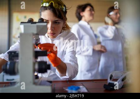 Female working with microscope in laboratory Stock Photo