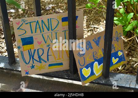Demonstration signs are seen at Bowling Green Park in New York City to stand in Solidarity with Ukraine on April 23, 2022. Stock Photo
