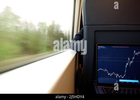 Defocus focus, open laptop or notebook, working as trader or stock trading on the train during commute. Graph on laptop in the train. Stock Photo