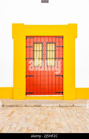 red and yellow abstract door in white wall of painted building Seville Sevilla Spain Stock Photo