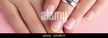Close up manicured womans hands on pink background Stock Photo