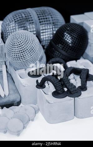 Many different models printed on 3D printer. Gray and black objects printed Stock Photo