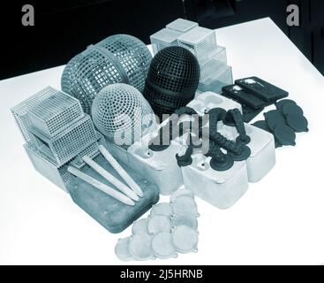 Many different models printed on 3D printer. Gray and black objects printed Stock Photo