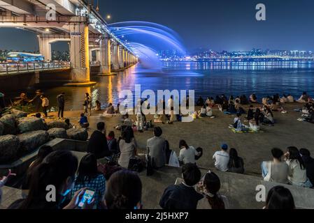 People gather to watch Banpo Bridge Moonlight Rainbow Fountain in Seoul, South Korea on 23 April 2022 Stock Photo