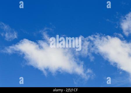 White clouds floating in a bright blue sky Stock Photo