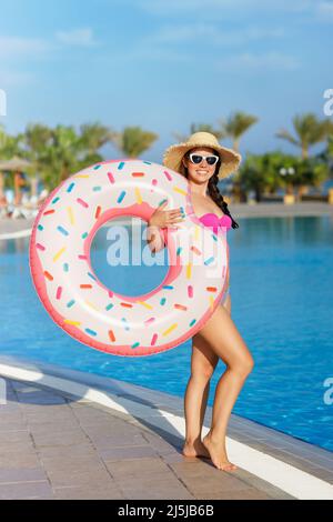 full length view of shapely girl in swimsuit with balloons and inflatable  beach balls smiling on Stock Photo by LightFieldStudios